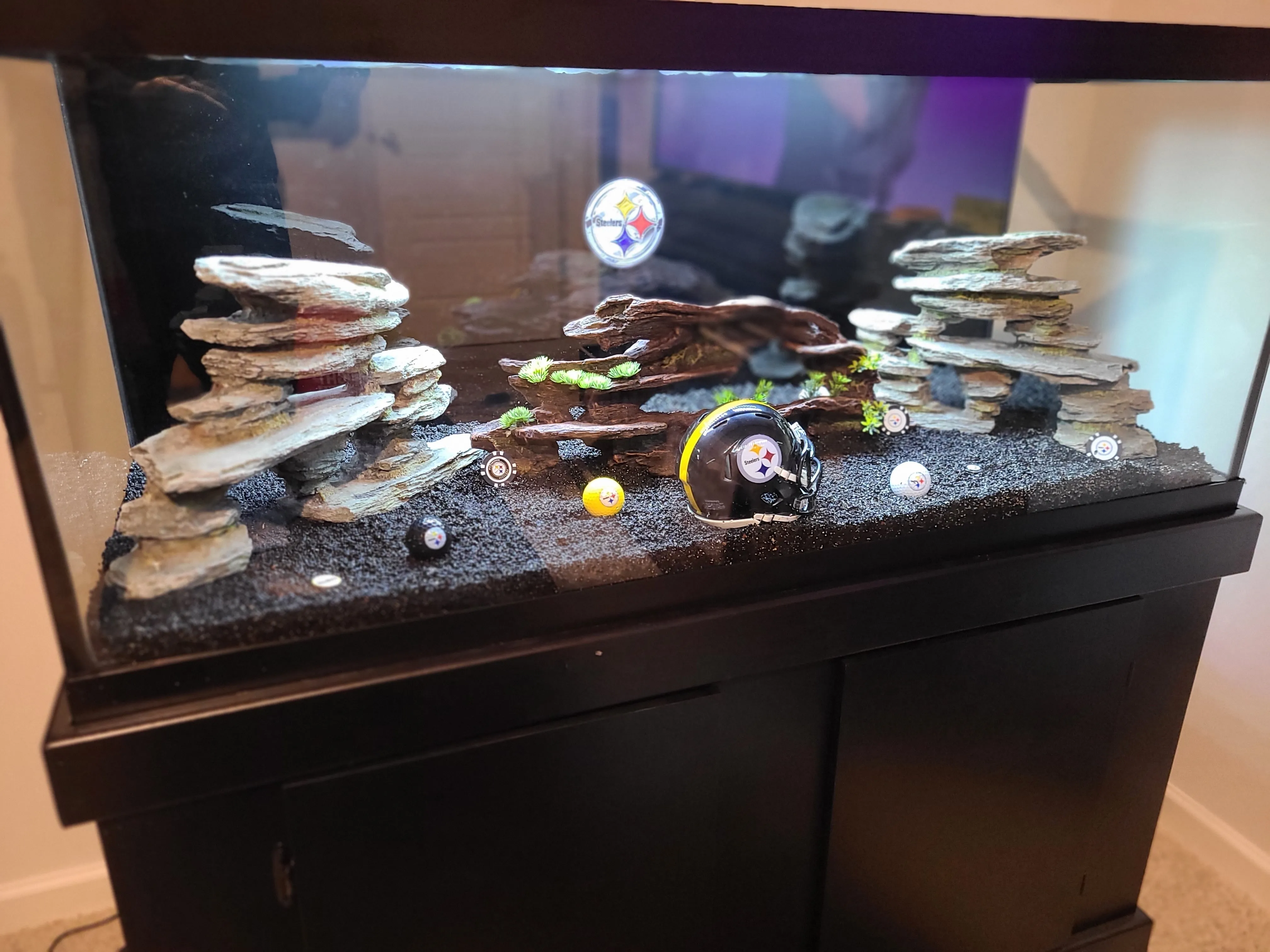 Pittsburgh Steelers-themed custom aquarium by Double Vision Aquatics with team helmet, logo golf balls, and slate rock hardscape